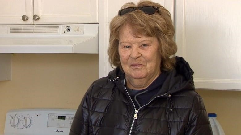 woman in black winter jacket in apartment kitchen