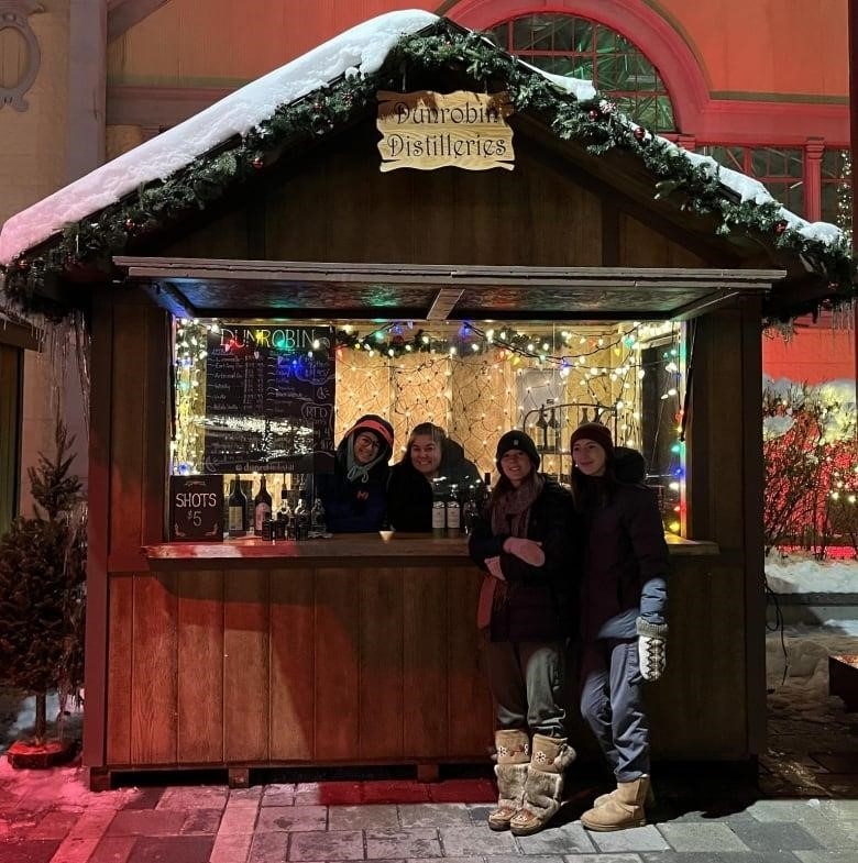 Dunrobin Distilleries employees in front of wooden shack at Lansdowne Christmas Market.  