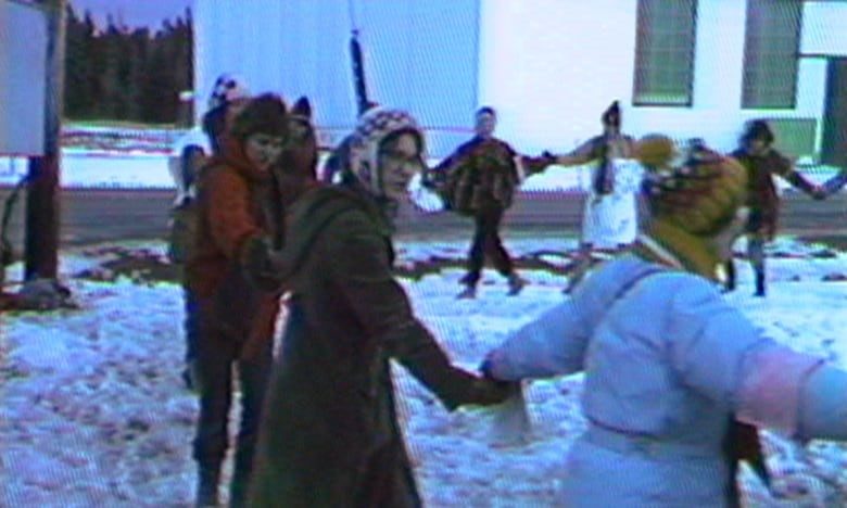 A group of women holding hands walk around the circle on a snowy day in Debert.