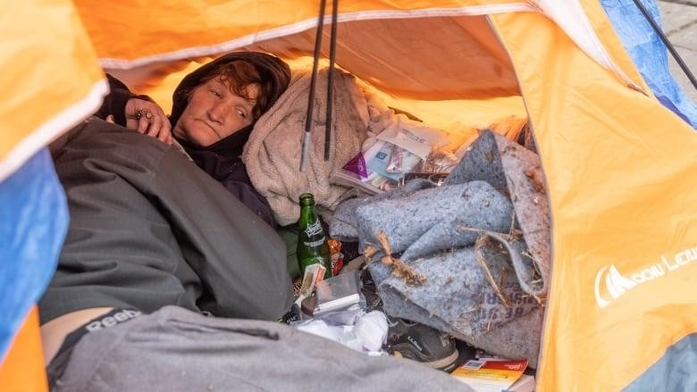 A person experiencing homelessness is inside a tent in Portland, Oregon.
