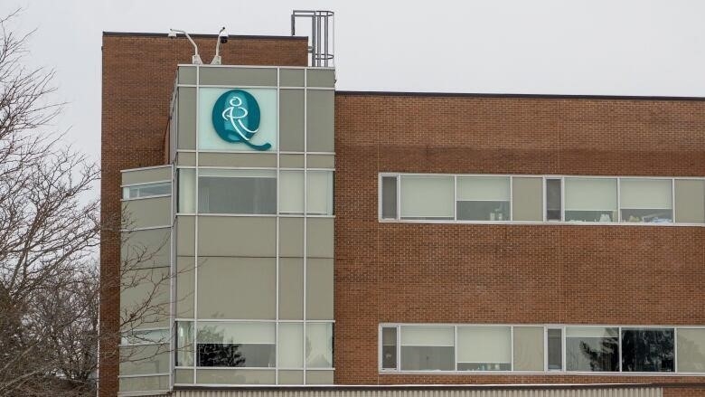 A Q logo on a brick hospital building.