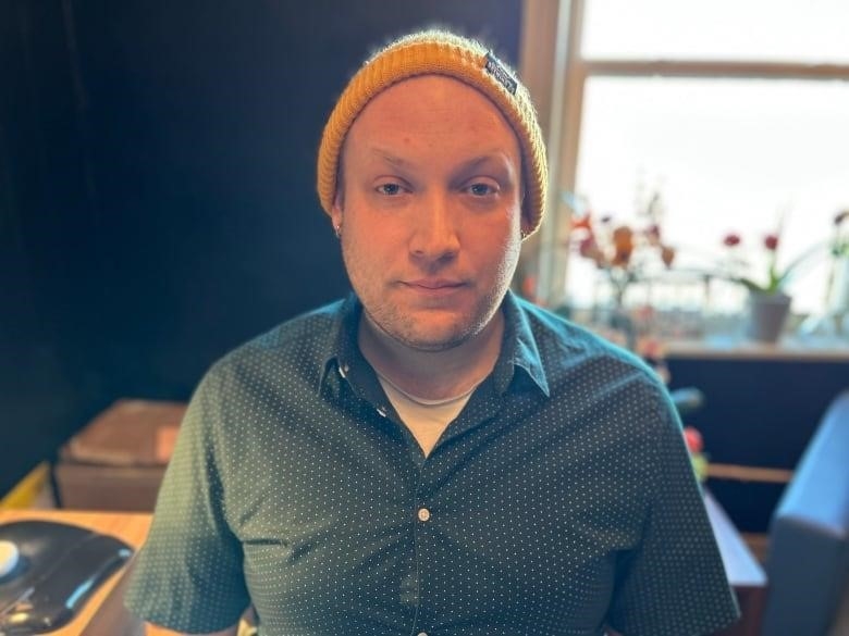 man in yellow toque and collared shirt in office