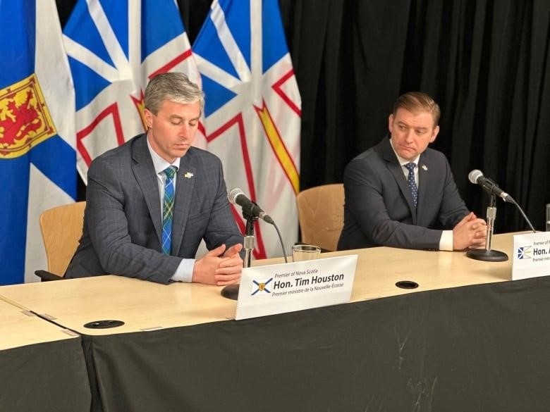 Tim Houston and Andrew Furey sitting side by side at a desk.