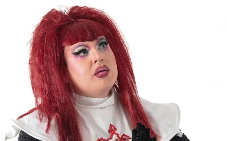 drag queen with red hair looking up
