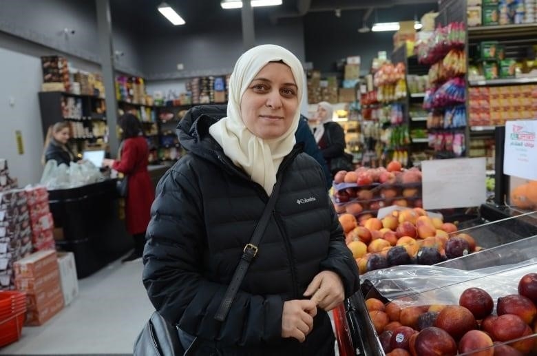 woman in hijab smiles in a grocery store
