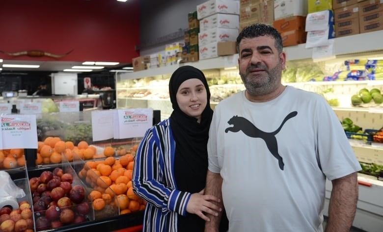 couple looks at camera in grocery store 