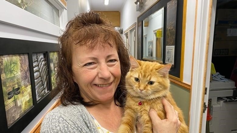 Jamie Svennes holds their new office foster cat. Century 21 Fusion in Saskatoon became the first business to foster an SPCA cat under the new program. 