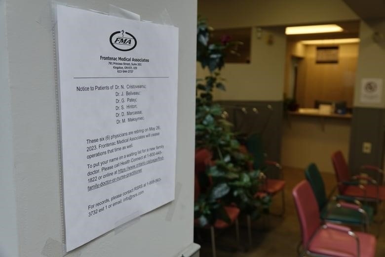 A white piece of paper lists the names of six doctors and says they're going to retire as of May 26, 2023. A row of chairs, a plant and a counter can be seen in the background.