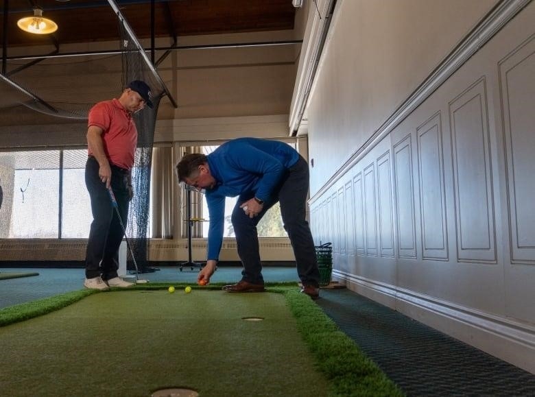 Two men on a putting green.