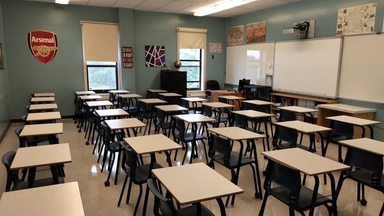 An empty classroom with several empty desks. 
