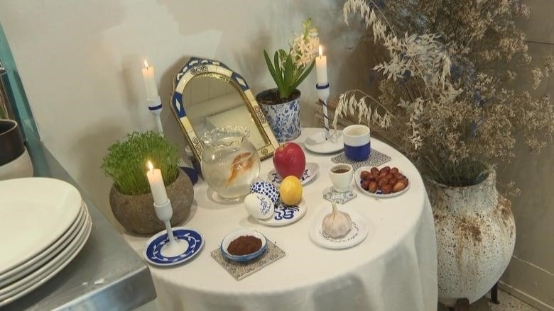 A table with a white tablecloth shows a number of assorted items, including garlic, an apple, a lemon, and vinegar. 