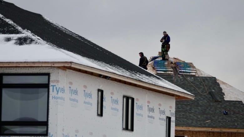A photo of a new home in Ottawa getting its shingles intalled. 