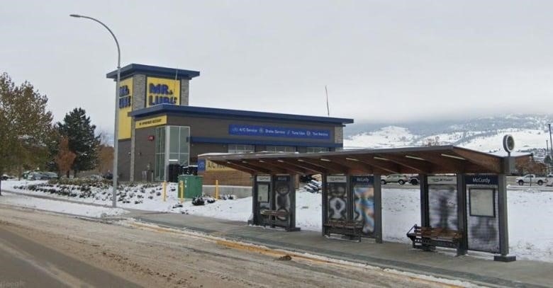 A bus stop as seen in winter along Highway 97 in Kelowna, B.C., with commercial buildings in the background. 