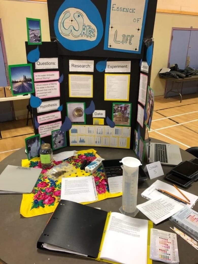 A Science project looking at the quality of water is set up on a table in a school gym.