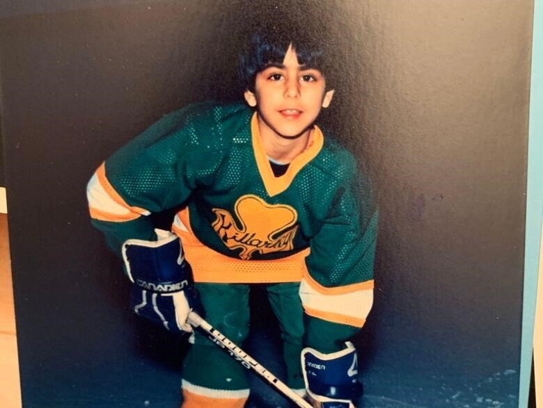 A young boy poses for a hockey photo.