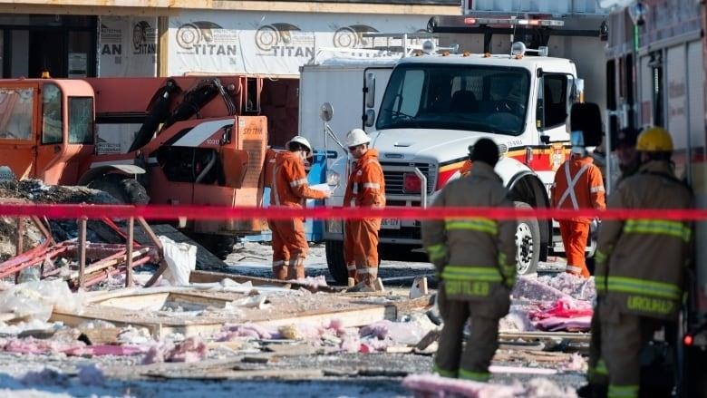 Workers examine the scene of an early morning gas leak explosion in the Orléans area of Ottawa, on Monday, Feb. 13, 2023. THE CANADIAN PRESS/Spencer Colby