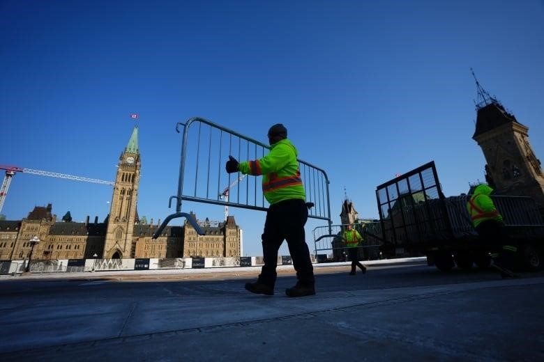 Workers set up a temporary fence in front of a legislature.