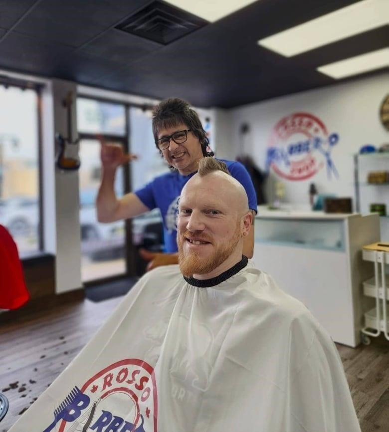 Barber Rosso Villamil cuts customer Justin Newhook's hair on Saturday at his Stratford shop's grand opening.