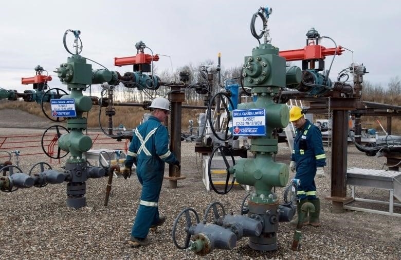 Two workers are at a multi-well pad at a natural gas plant near Fort St. John B.C.