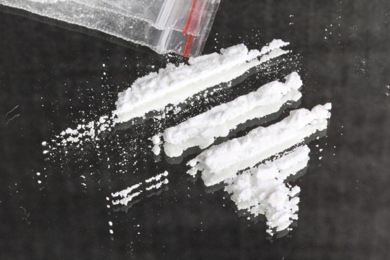 Powdered cocaine is arranged into lines on reflective surface