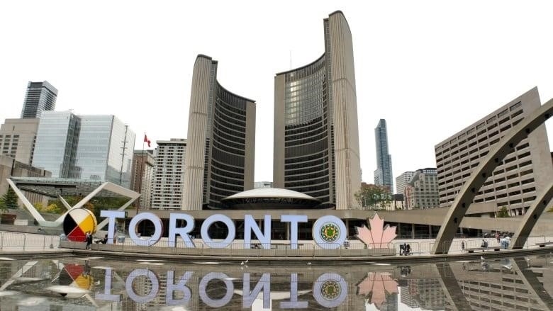 A picture of Toronto City Hall shows the Toronto sign and the iconic building.