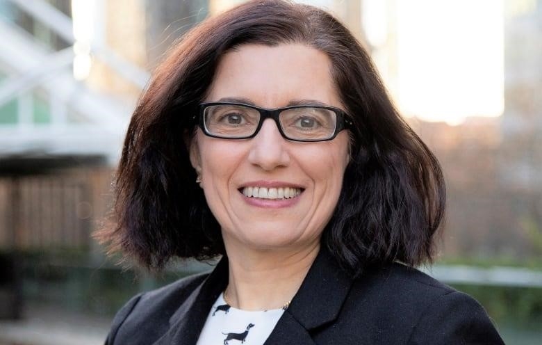 Portrait of woman with dark hair and glasses.