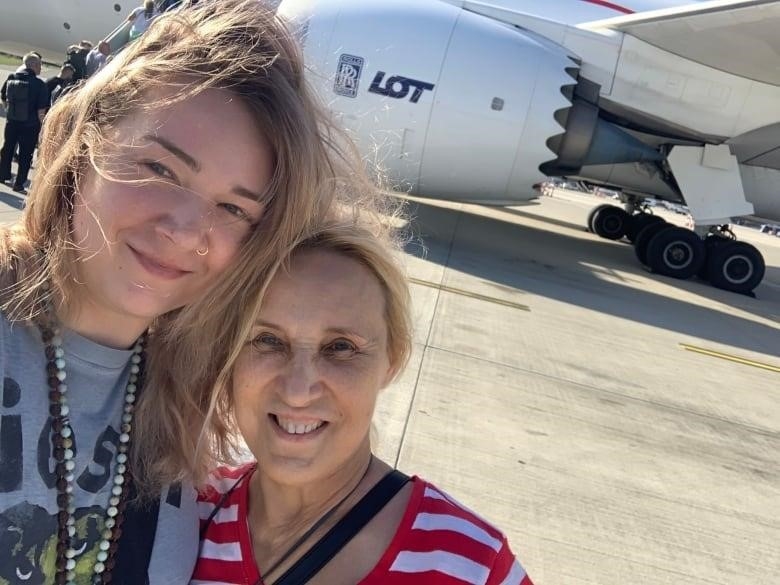 A daughter and her mother pose for a picture while on vacation. 