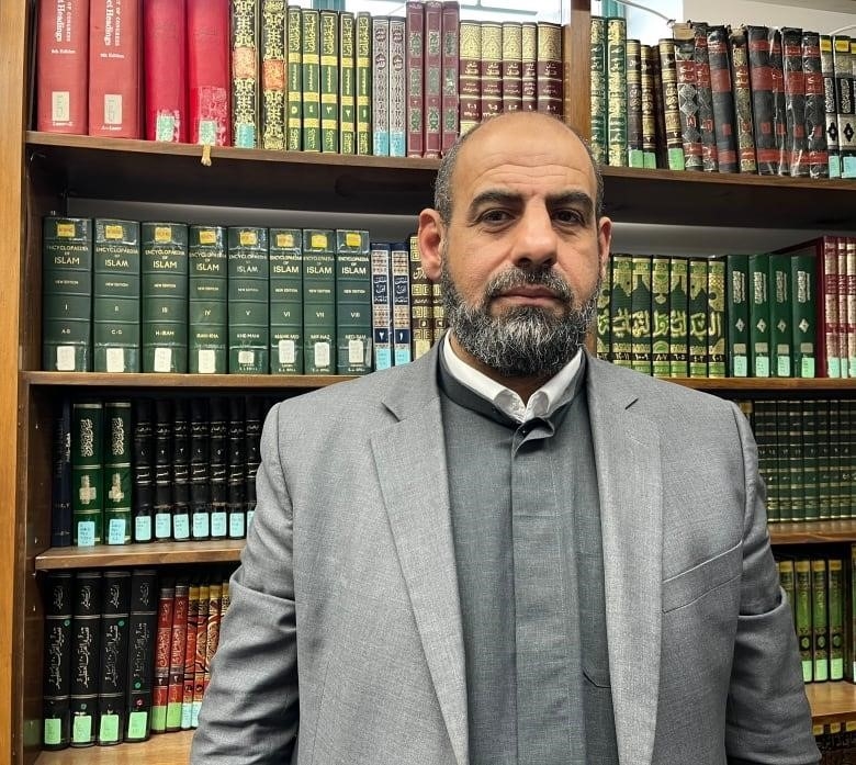 man standing in front of bookshelf