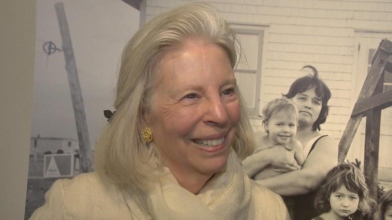 close up photo of middle aged woman smiling with grey hair