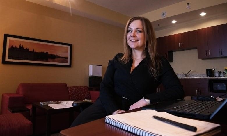 A woman sits at a desk.