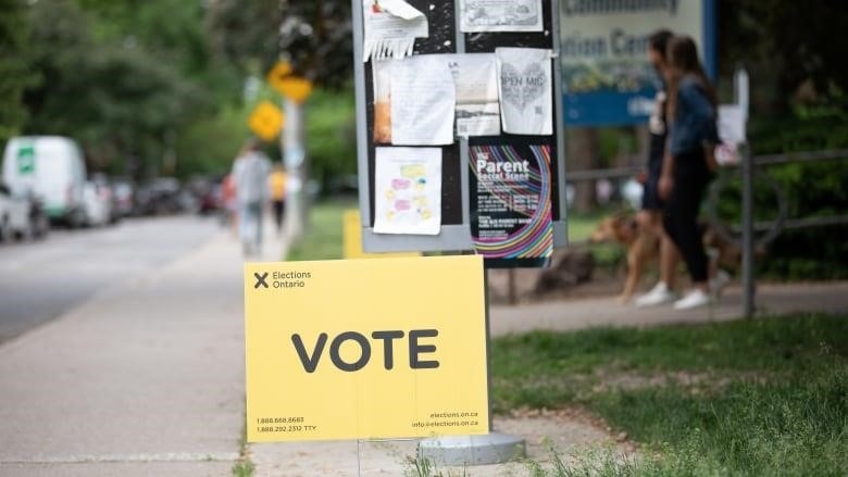 Yellow Elections Ontario sign reading "VOTE" outside a polling station. 