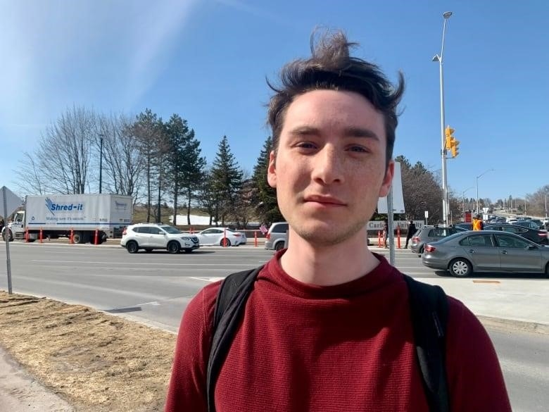 A male student stands outside the Carleton University campus.