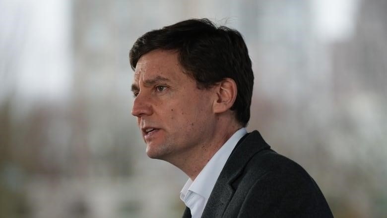 B.C. Premier David Eby is pictured in a grey suit and white shirt.