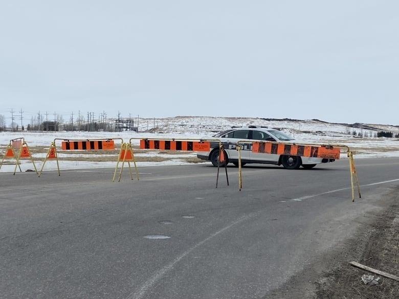 A Winnipeg police car was seen behind barricades set up by Brady Landfill in Winnipeg on Tuesday.