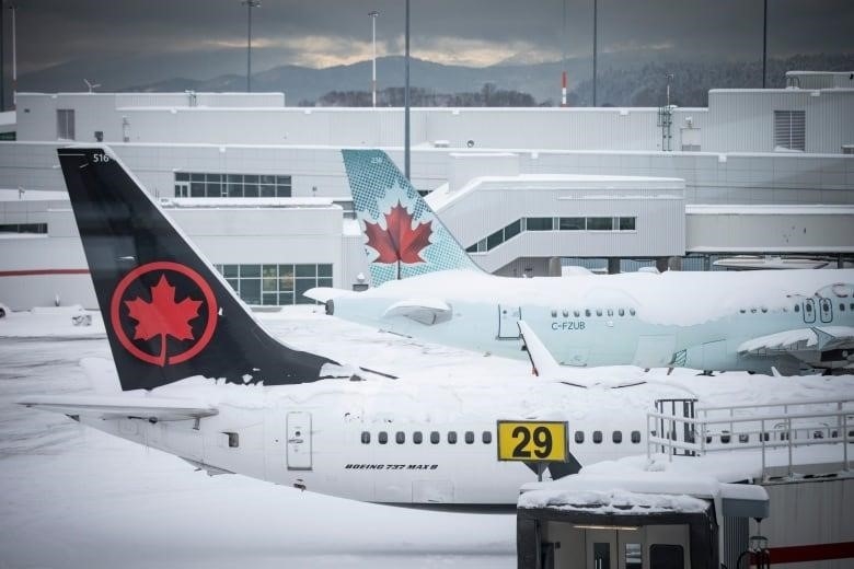 Airplanes are pictured at an airport after a heavy snowfall.