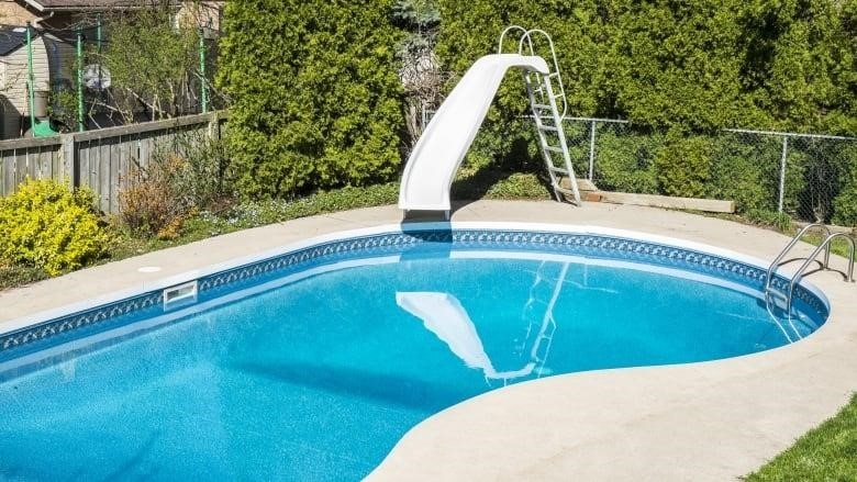 Backyard in-ground pool with fence around it.