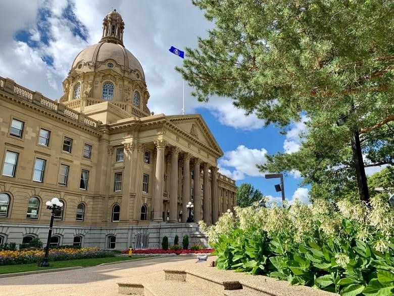 A sandstone public building is seen from a wide angle