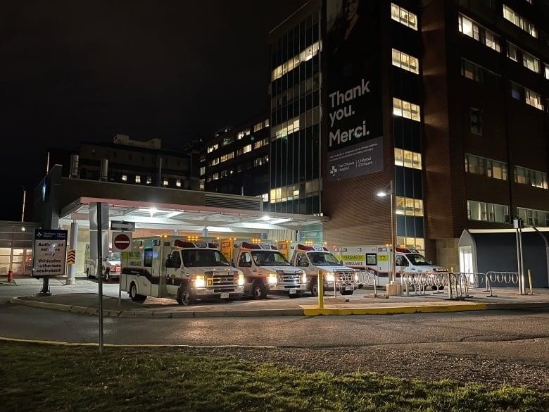 Five ambulances outside a hospital at night.