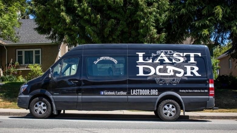 A black van with the name 'Last Door' is printed on the back. 