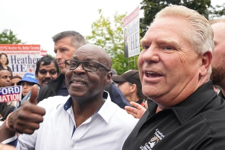 Toronto mayoral candidate Mark Saunders walks with Ontario Premier Doug Ford in front of a crowd holding 'Ford Fest' signs, 