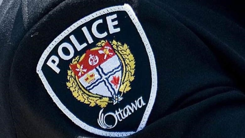 A close-up of the Ottawa police crest on an officer's uniform.