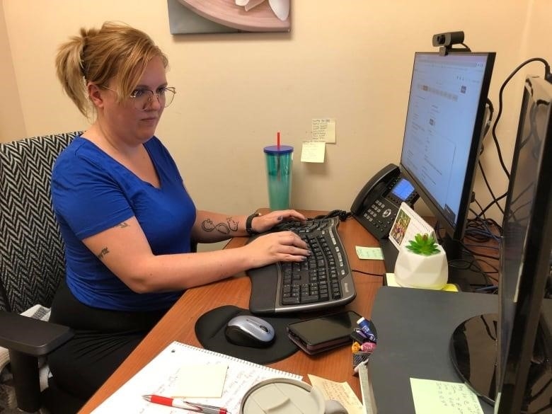 A woman sits at a computer.