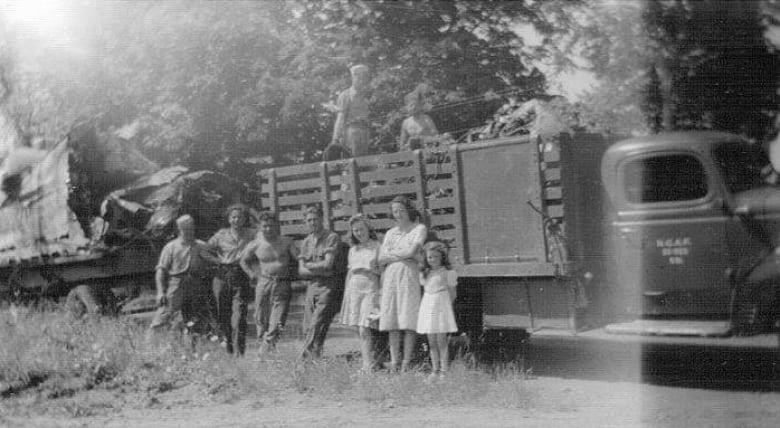 A black-and-white photo shows wreckage from the crash being loaded on to a Royal Canadian Air Force truck.