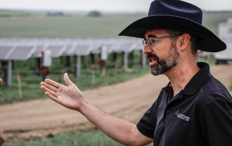 A main in a cowboy hat speaking.