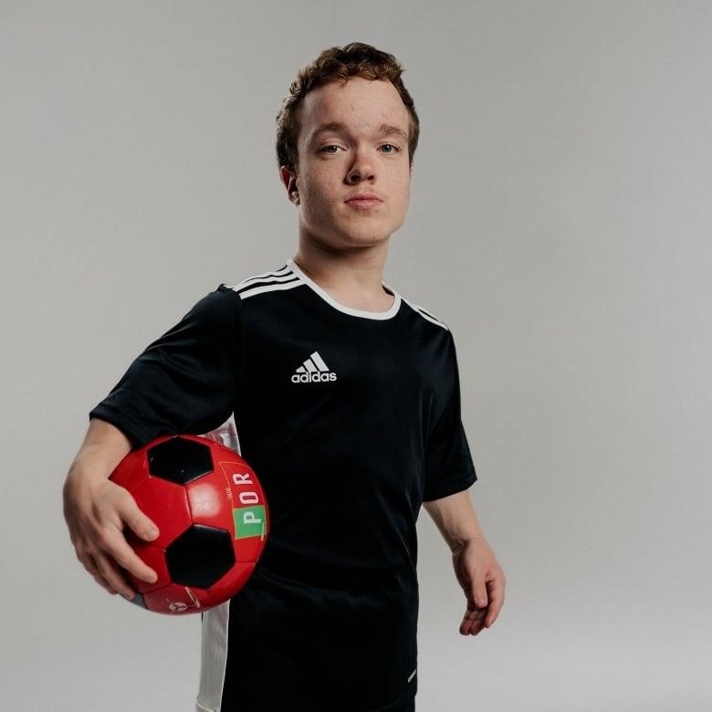 A man holding a soccer ball against a blank background