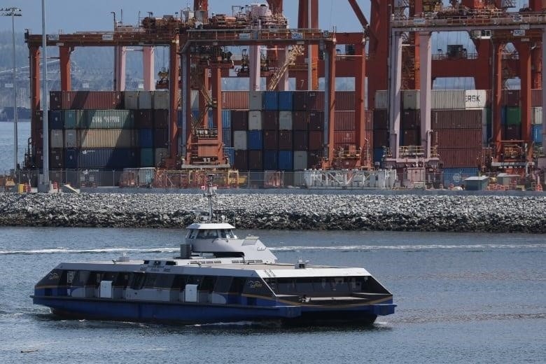 A seabus passes containers sitting idle on the dock at the Port of Vancouver.