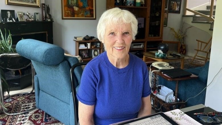 A woman sits in front of an iPad.