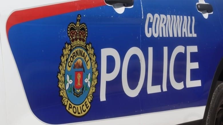 A police service crest depicting a beaver, a crown and two flowers is seen on the side of a police cruiser.