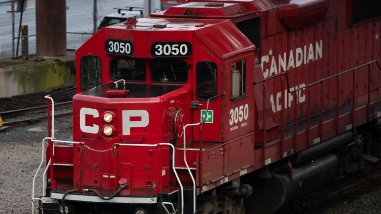 A red train is pictured on the track with Canadian Pacific written in white letters. 
