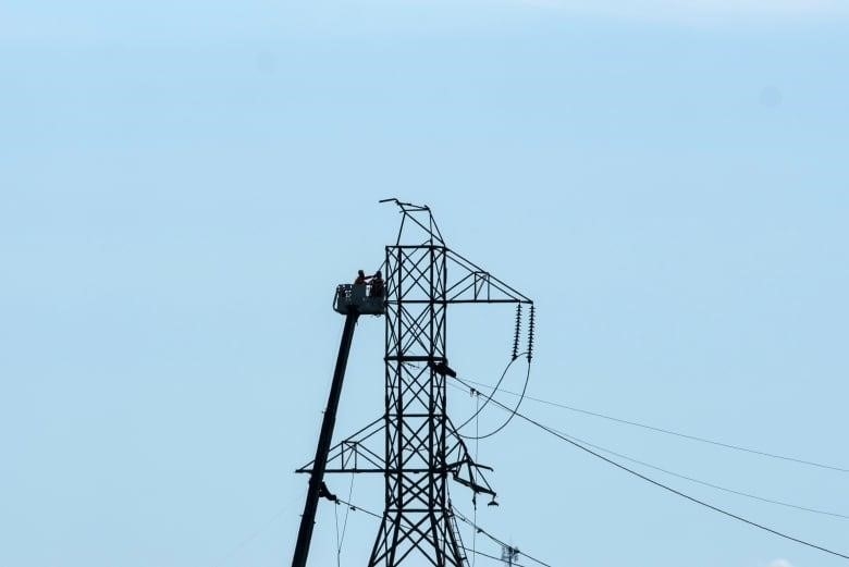 Crews work on a damaged power transmission tower in Ottawa in May of 2022.